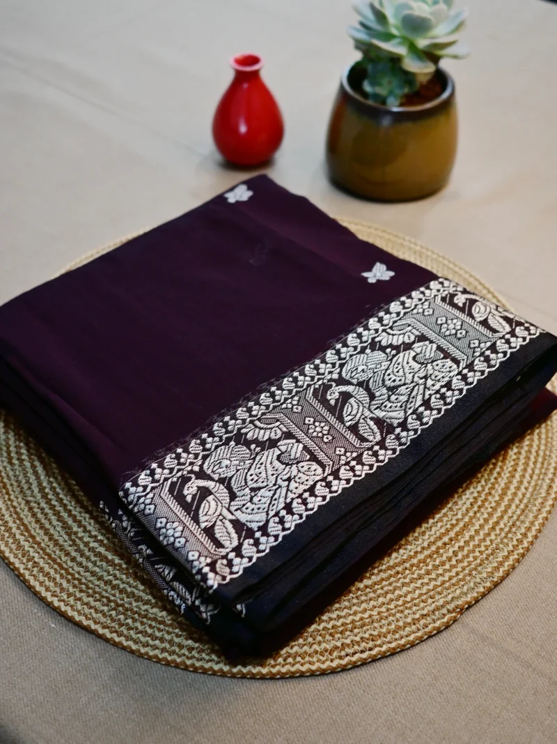 Dark brown cotton Baluchari saree with white border.