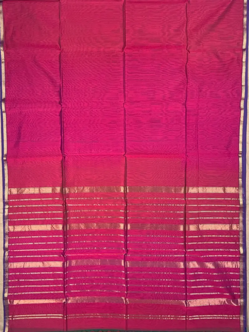 Pallu of A silk‑cotton Maheshwari saree with shades of magenta, blending heritage and modern elegance. The beauty of plain saree is accentuated by a narrow blue border with golden jari. A coordinated pallu highlights its elegance. Paired with a matching blouse piece, it’s a luxurious, tasteful choice for festive occasions and family gatherings.